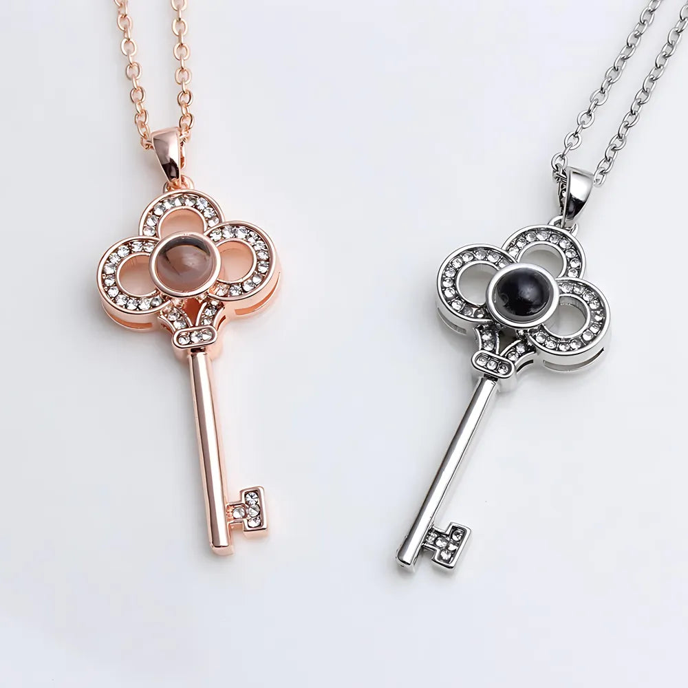 Two key-shaped pendants on necklaces against a white background