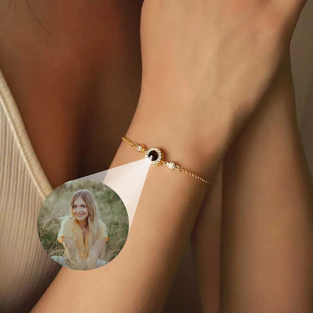 Gold bracelet with a black stone on a wrist, inset with a photo of a woman.
