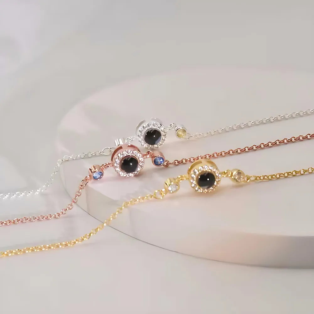 Three gold and silver bracelets with black stones on a white surface