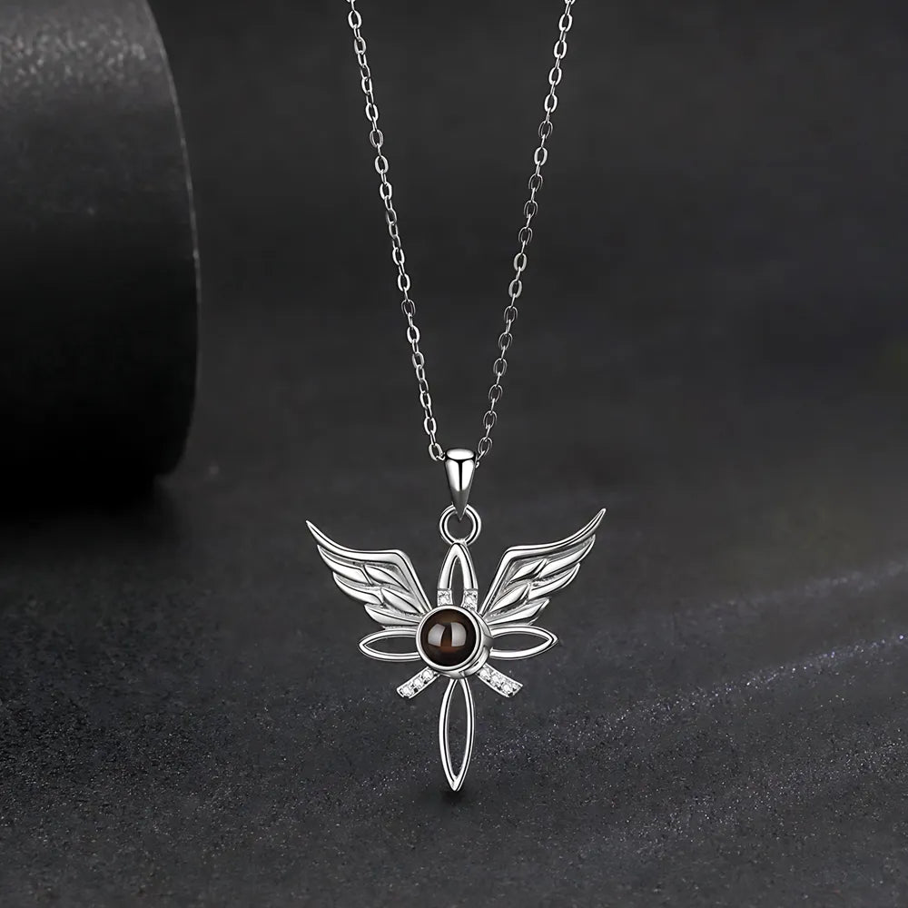 Silver pendant necklace with a dark stone on a black background