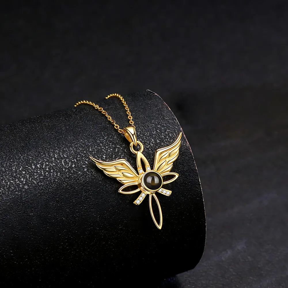 Gold butterfly pendant with a black gemstone on a dark background