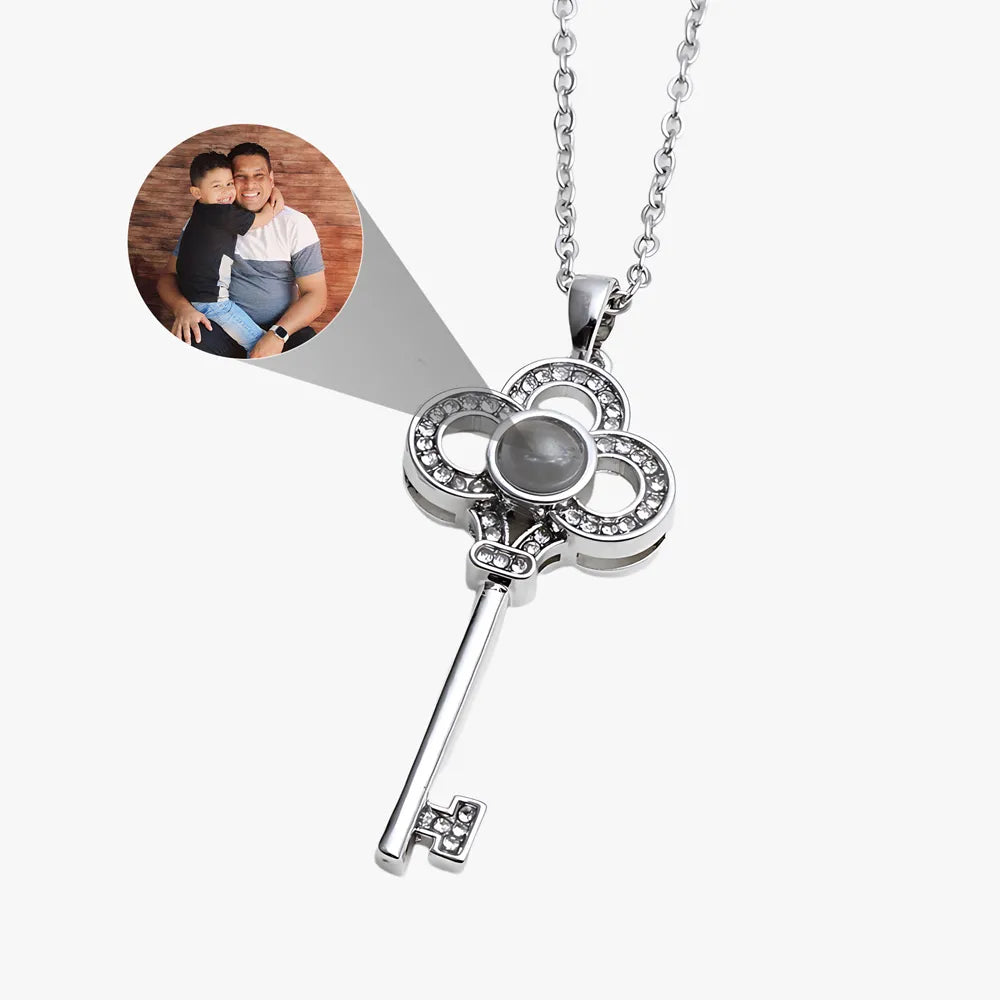 Silver key-shaped pendant with cross design on a white background